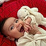 baby, smiling, infant, stuffed_toy, bunny, red_blanket, happy, cute, clothing, soft_toy, child, portrait, lying_down, hand, face, cozy, indoors, warm, toddler, expression