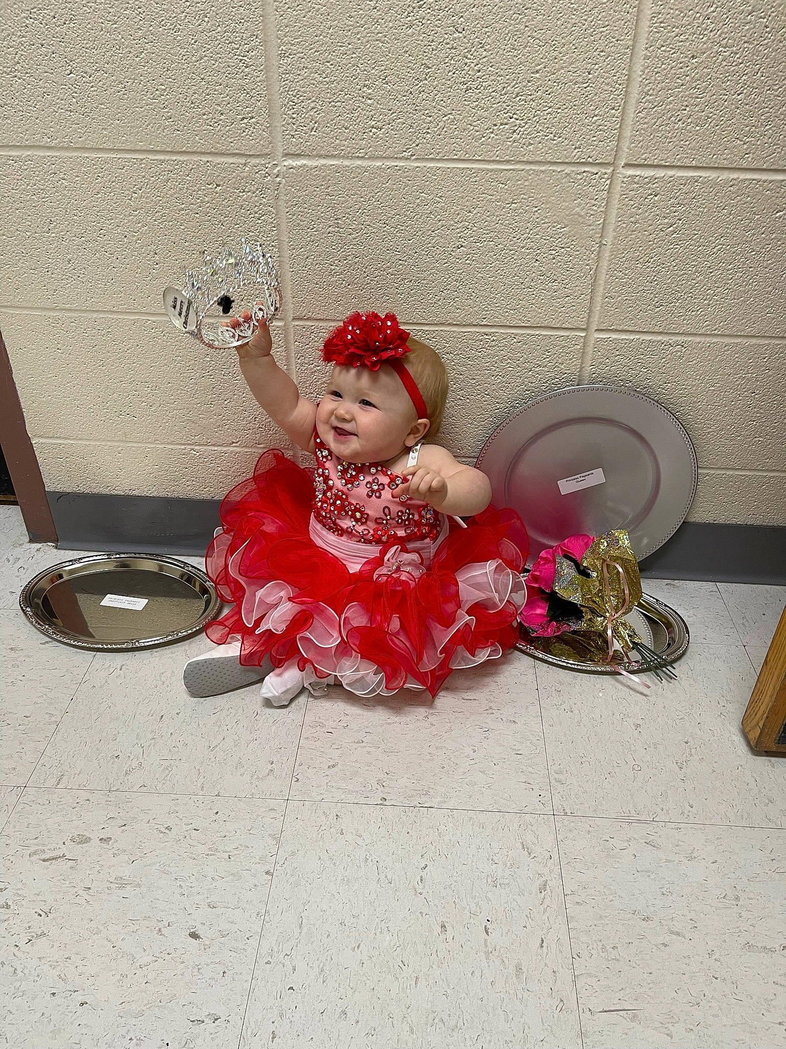 Oaklynn is registered to the contest to win money with this photo: art, baby_toddler_clothing, carmine, child, costume, costume_hat, dress, fashion_accessory, floor, flooring, hair_accessory, happy, headpiece, headwear, joy, magenta, person, sandal, sitting, toddler