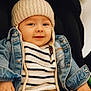 baby, child, hat, knit_hat, denim_jacket, striped_sweater, brown_pants, smile, face, portrait, sitting, cute, cozy, warm_lighting, indoor, clothing, baby_hand, casual, fashion, infant