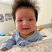 Grace is registered to the contest to win money with this photo: baby, bed, blanket, blue_clothing, child, couch, cute, face, furniture, hair, happy, head, home, indoor, infant, person, portrait, skin, smile, spiky_hair