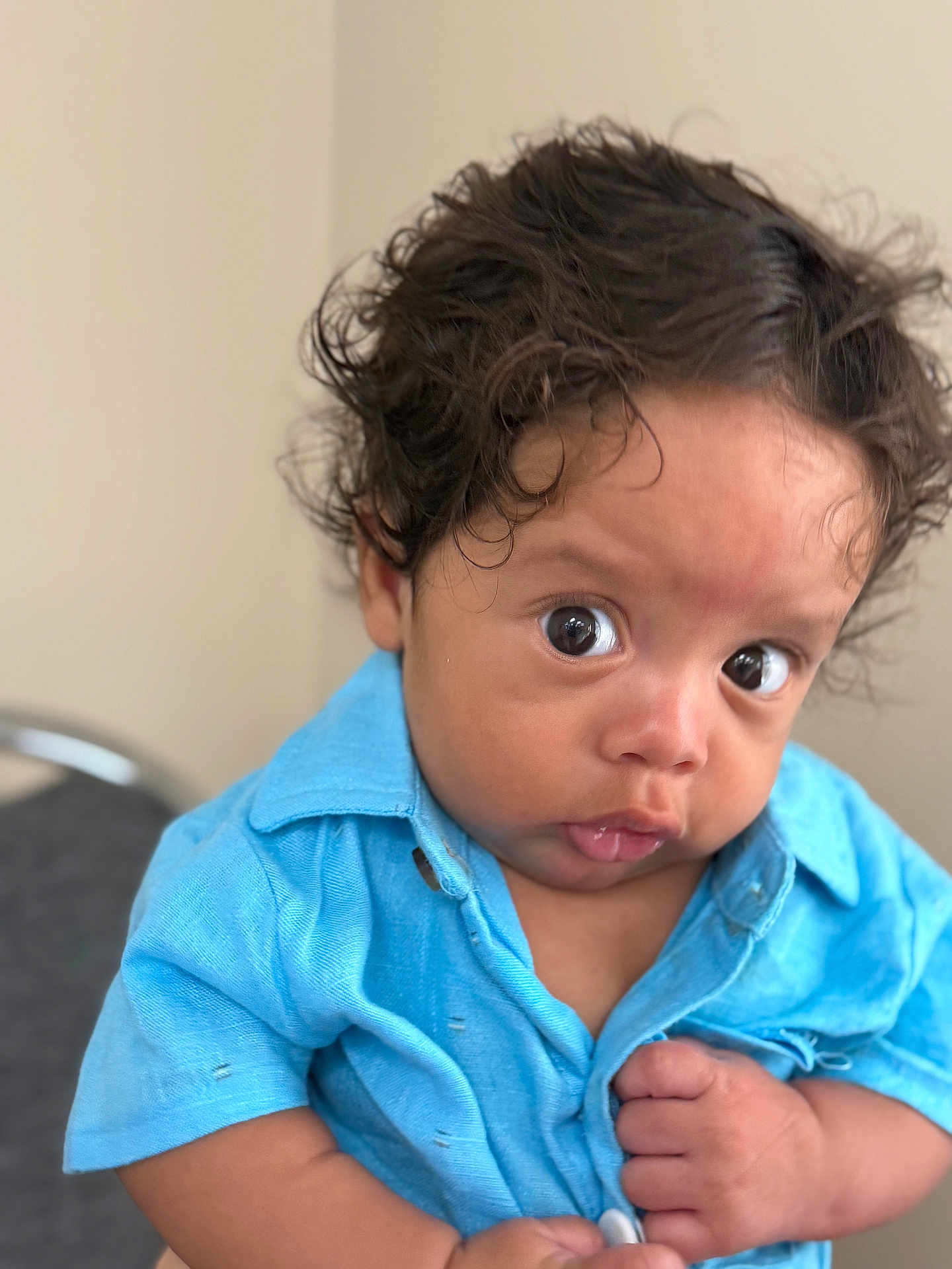 Jayton joined the competition — help win amazing prizes! baby, child, curly_hair, blue_shirt, clothing, face, eyes, hands, portrait, indoor, skin, expression, infant, person, cute, young, closeup, button, curious, human