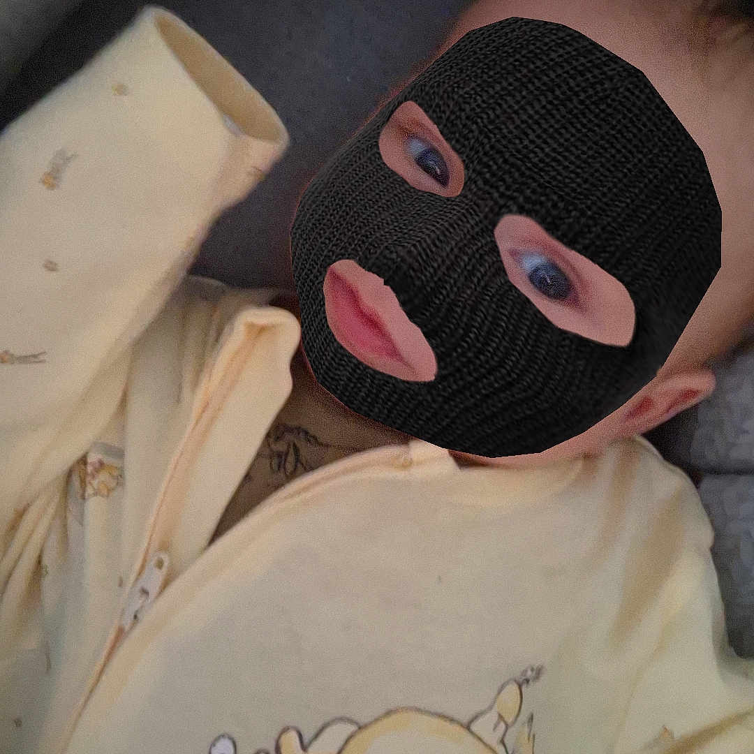 Torino a rejoint le concours — aidez-le/la à gagner de superbes lots ! baby, blanket, cartoon_print, child, cozy, cute, eyes, fabric, face, hand, indoors, infant, lying_down, mask, mouth, onesie, portrait, ski_mask, soft, yellow_clothing