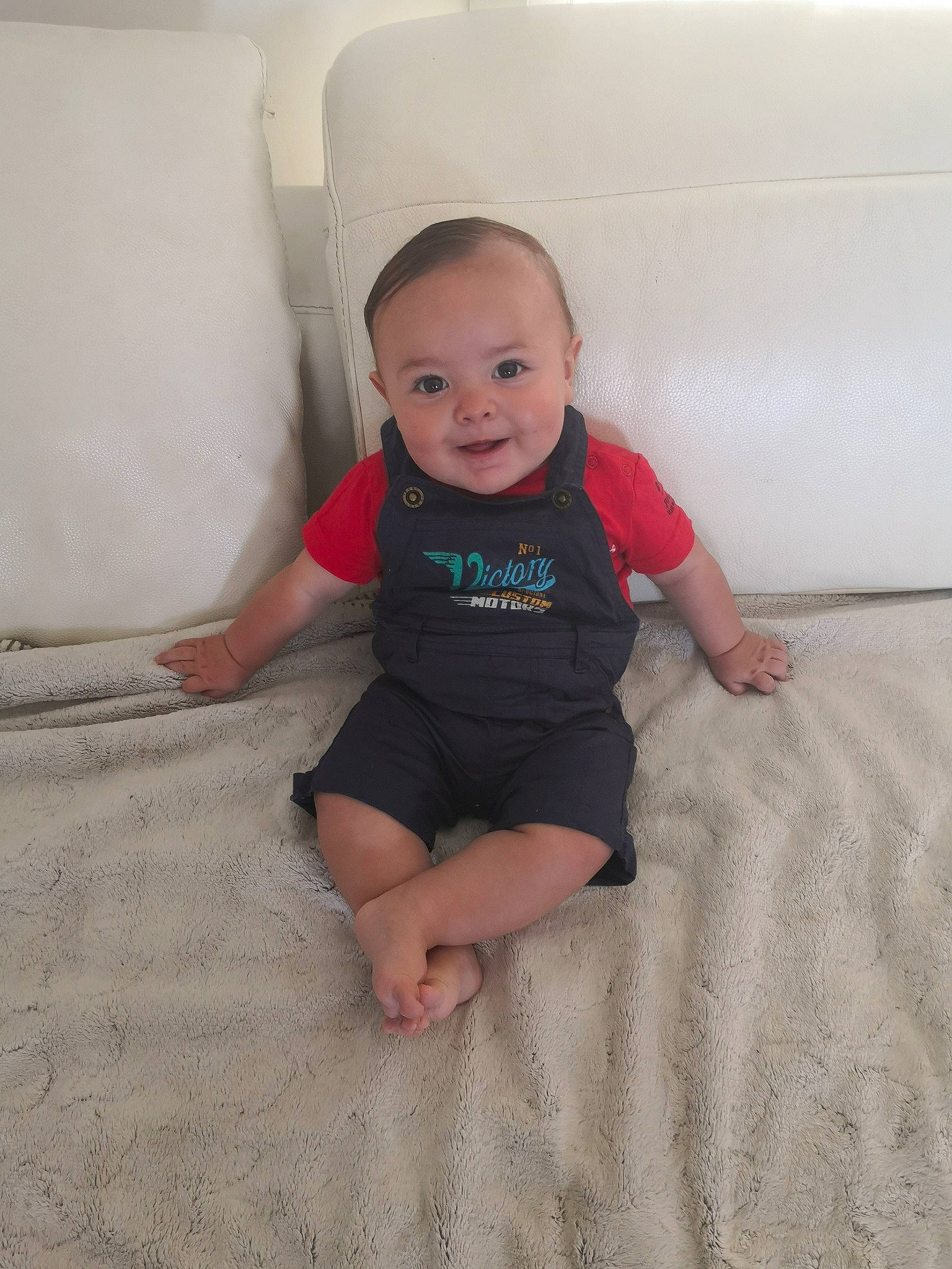 Léo participe au concours pour gagner de l'argent avec cette photo : baby, barefoot, child, floor, flooring, leg, person, sitting, skin, smile, standing, toddler