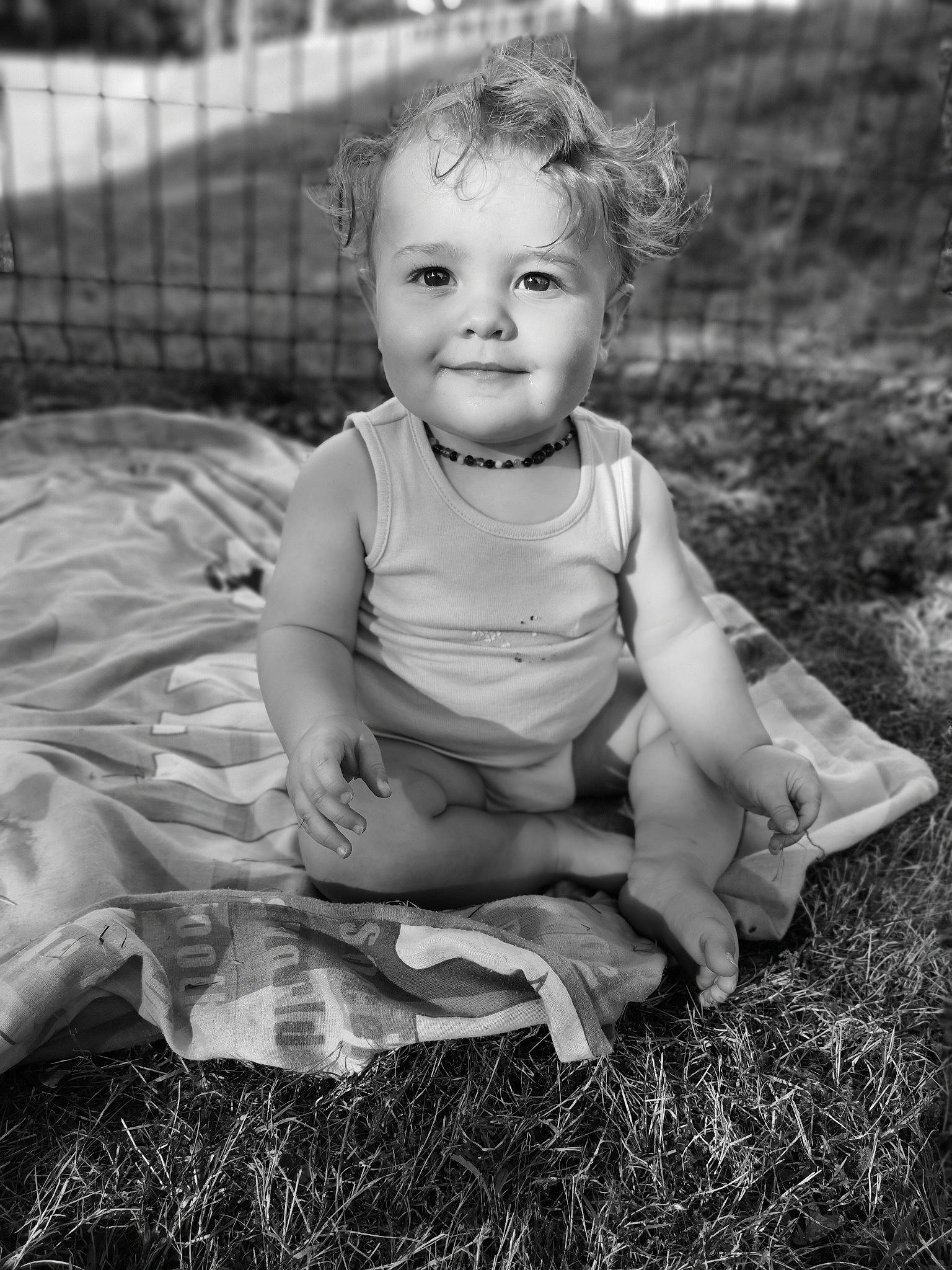 Léo a rejoint le concours — aidez-le/la à gagner de superbes lots ! baby, black_and_white, child, dress, eye, face, grass, iris, joy, monochrome, monochrome_photography, people, person, photograph, photography, portrait, portrait_photography, sitting, smile, snapshot