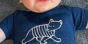 Ishaïm a rejoint le concours — aidez-le/la à gagner de superbes lots ! baby, infant, onesie, clothing, blue, bear_graphic, text, petit_bateau, lying_down, fluffy_surface, gray_background, smiling, chubby_cheeks, cute, portrait, child, head, face, skin, happy