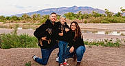 Merlin joined the competition — help win amazing prizes! family, outdoor, river, mountains, dog, child, adult, casual_clothing, smiling, nature, grass, sand, water, trees, glasses, kneeling, happy, portrait, pets, people