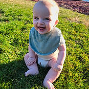 Myles is registered to the contest to win money with this photo: baby, smiling, grass, outdoor, sunlight, diaper, bib, child, happy, sitting, nature, greenery, daylight, face, infant, cute, skin, legs, feet, person