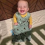 baby, infant, smiling, sleeping_sack, yellow_shirt, crib, wooden_crib, pacifier, patterned_sheet, bear_pattern, happy, child, indoors, shadow, lighting, cute, toddler, face, sitting, bedtime