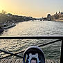 baby, infant, car_seat, blanket, sleeping, river, bridge, sunset, water, railing, wooden_planks, boat, cityscape, skyline, architecture, outdoor, travel, calm, portrait, golden_hour