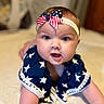 baby, infant, child, crawling, headband, bow, stars, blue_clothing, cute, face, skin, eyes, mouth, arm, soft_surface, indoor, portrait, closeup, happy, curious