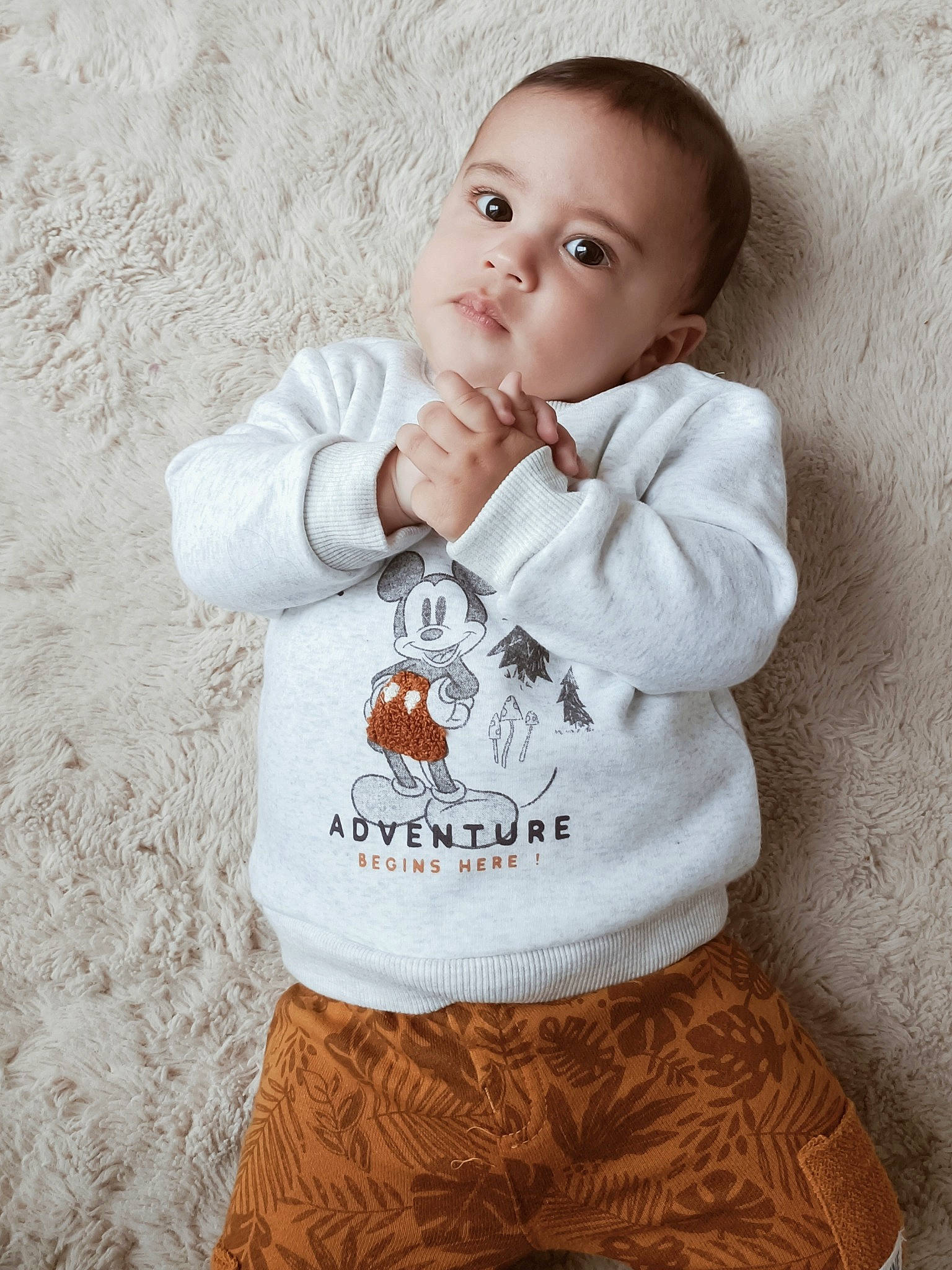 Maël participe au concours pour gagner de l'argent avec cette photo : arm, baby_toddler_clothing, cheek, eye, face, gesture, grey, hand, happy, head, human_body, iris, lip, neck, nose, organ, person, skin, sleeve, white