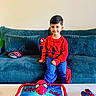 Yasir is registered to the contest to win money with this photo: child, boy, birthday, spiderman, superhero, red_shirt, blue_pants, smiling, sitting, sofa, couch, cake, birthday_cake, toy_car, mask, living_room, indoor, wall_art, portrait, celebration