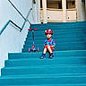 Yasir joined the competition — help win amazing prizes! child, boy, superhero, spiderman, helmet, scooter, stairs, staircase, outdoor, building, architecture, portrait, sitting, colorful, blue, red, playful, clothing, shoes, urban