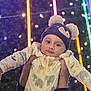 Adriel joined the competition — help win amazing prizes! baby, child, hat, pom_poms, onesie, animal_print, hands, person, face, eyes, cozy, warm_clothing, night, lights, bokeh, colorful_lights, background, portrait, festive, outdoor