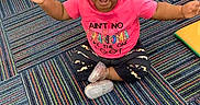Alora joined the competition — help win amazing prizes! baby, child, smiling, pink_shirt, cross_legged, carpet, indoor, happy, person, cute, hair_puffs, toddler, colorful, striped_carpet, footwear, sitting, playroom, toy, floor, expression