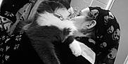 Soren participe au concours pour gagner de l'argent avec cette photo : cat, person, glasses, bandana, skull_pattern, hugging, selfie, mirror, phone, black_and_white, indoor, coat, wall, reflection, furry, pet, affection, closeup, portrait, casual