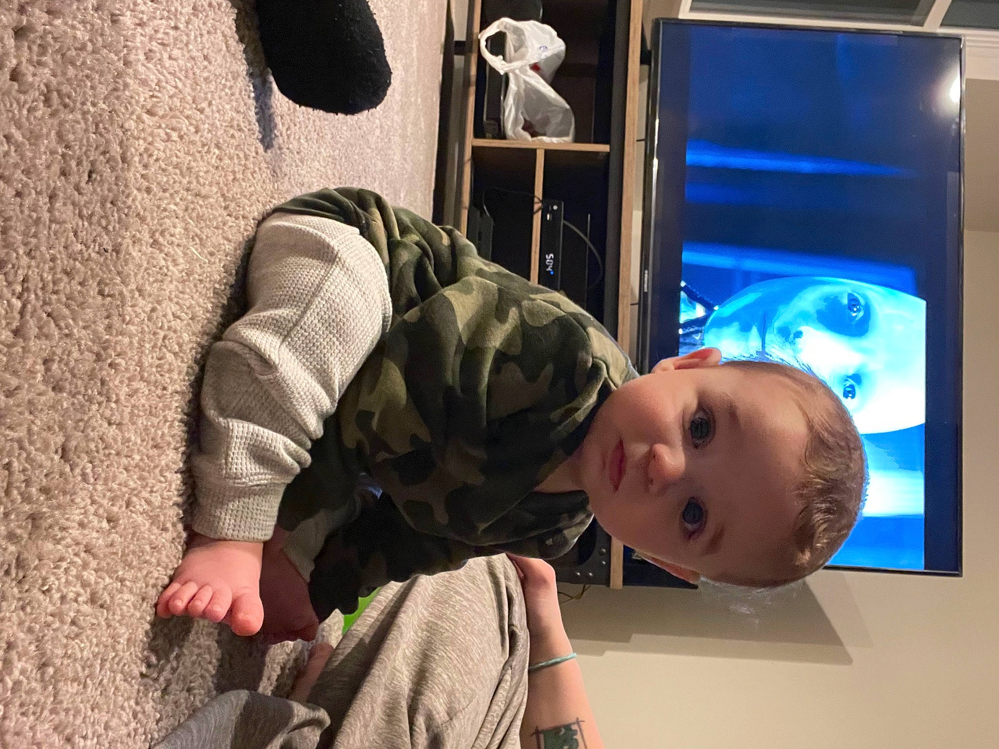 Thor is registered to the contest to win money with this photo: audio_equipment, baby, baby_toddler_clothing, child, display_device, flat_panel_display, flooring, fun, gadget, machine, multimedia, person, personal_protective_equipment, room, sitting, television_set, toddler, vacation, wood