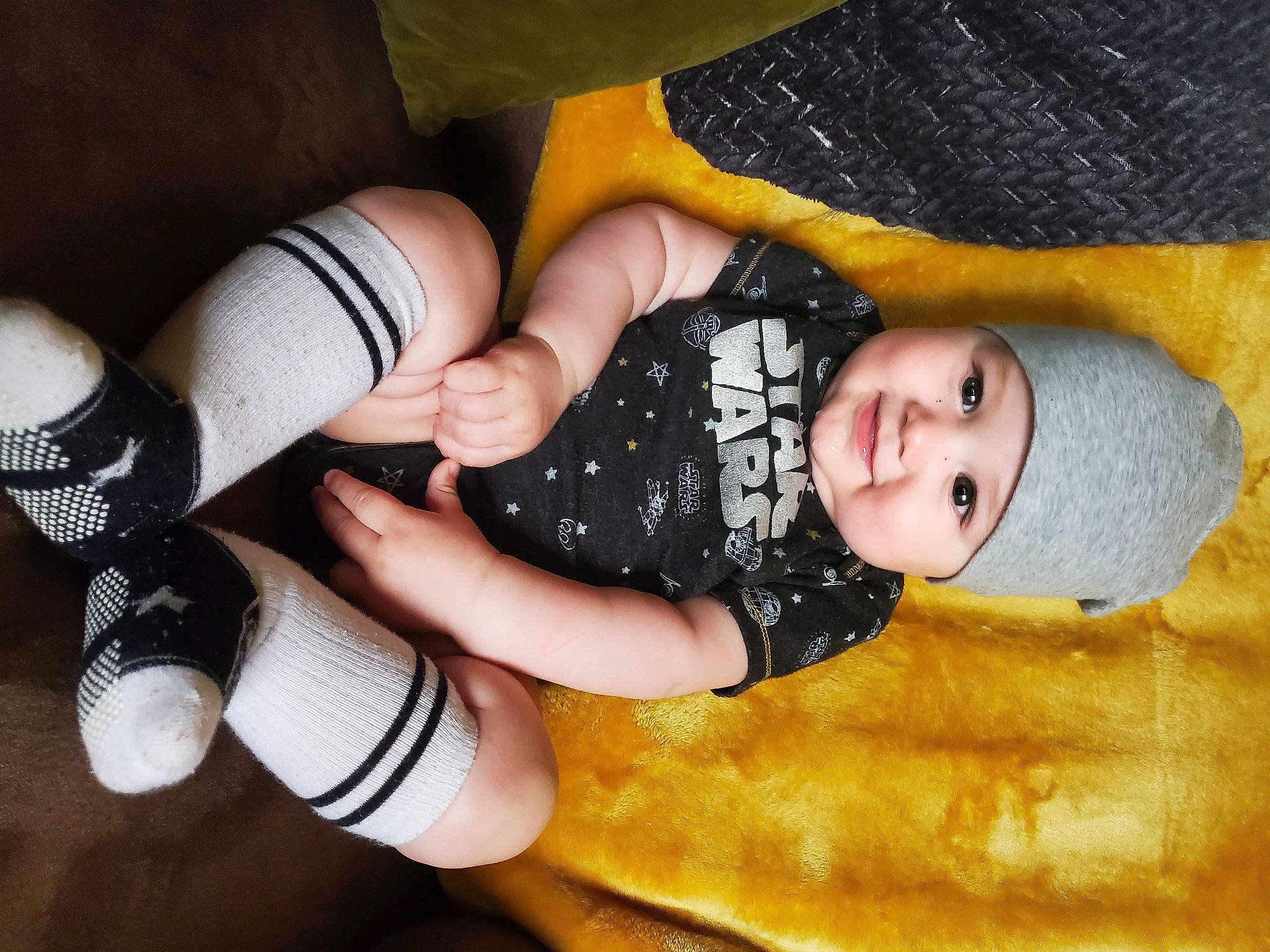 Paul is registered to the contest to win money with this photo: arm, baby_toddler_clothing, black_hair, finger, gesture, hand, happy, headgear, headwear, human_body, joint, joy, knee, leg, nail, person, smile, textile, thigh, thumb