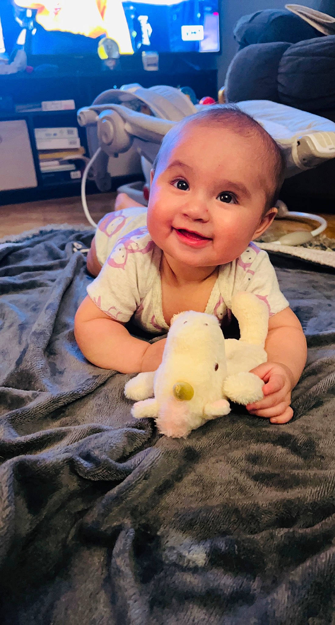 Lilianna joined the competition — help win amazing prizes! baby, baby_toddler_clothing, baby_toys, cheek, child, face, finger, flooring, happy, joy, nail, person, plush, room, sitting, skin, smile, stuffed_toy, teddy_bear, thumb