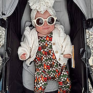 Oaklynn joined the competition — help win amazing prizes! baby, stroller, sunglasses, headwrap, bow, white_cardigan, patterned_outfit, cherry_pattern, designer_logos, infant, child, fashion, cute, smiling, outdoor, footwear, clothing, seat, baby_accessory, person