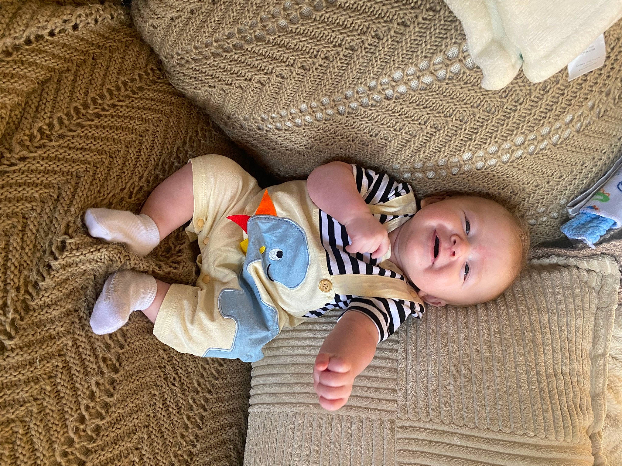 Declan is registered to the contest to win money with this photo: baby, baby_sleeping, baby_toddler_clothing, cheek, child, comfort, finger, flooring, foot, hand, joy, linens, mouth, nail, pattern, person, room, sitting, skin, textile