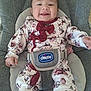 baby, smiling, child, infant, floral_outfit, bow, chicco, baby_seat, happy, cute, clothing, sitting, indoor, infant_toys, comfort, young_child, portrait, person, seatbelt, childcare