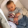 baby, infant, crib, plush_toy, giraffe, soft_toy, blue_pants, light_blue_top, blanket, cushion, bed, sleepwear, child, indoors, cute, hands, face, resting, comfort, toy