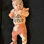Bellona is registered to the contest to win money with this photo: baby, infant, headband, bow, clothing, pink, peach, cute, lying_down, text, hello_world, socks, patterned_pants, soft_fabric, alert, indoor, portrait, newborn, child, person