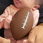 Bellona joined the competition — help win amazing prizes! baby, infant, football, hands, pajamas, person, child, cute, holding, soft_lighting, indoor, closeup, skin, fingers, face, looking, expression, small_football, adult, comfort