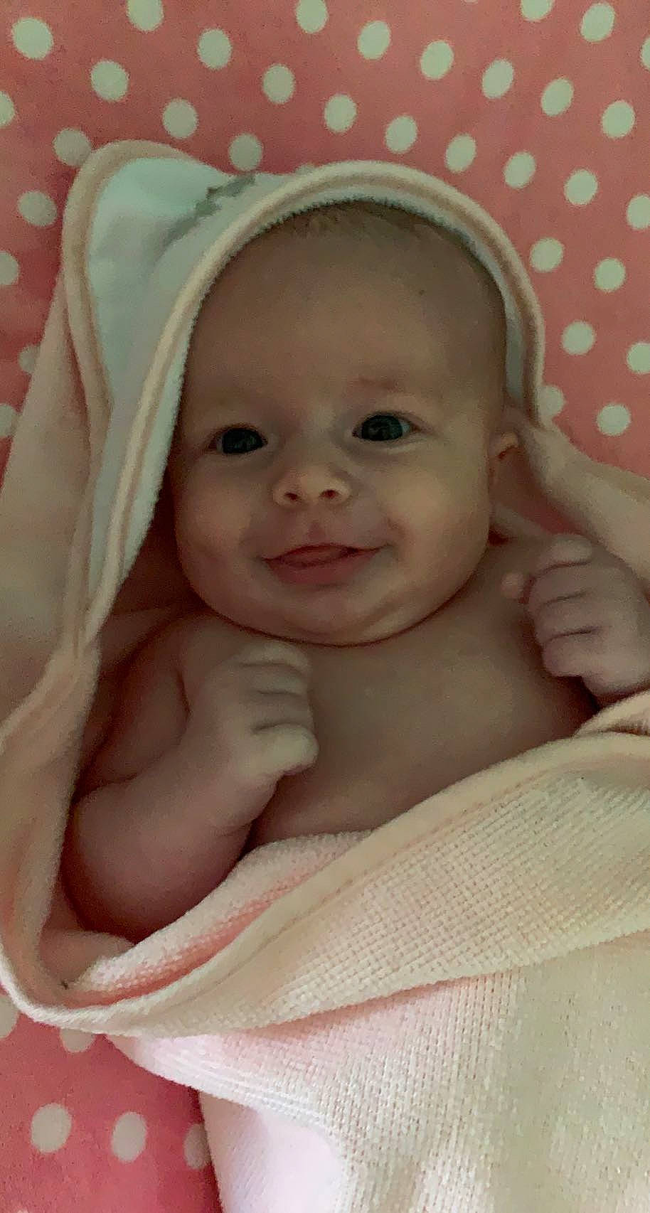 Emmalynn is registered to the contest to win money with this photo: baby, cheek, child, chin, comfort, eyebrow, eyelash, face, gesture, happy, iris, linens, lip, mouth, nose, person, pink, skin, sleeve, smile