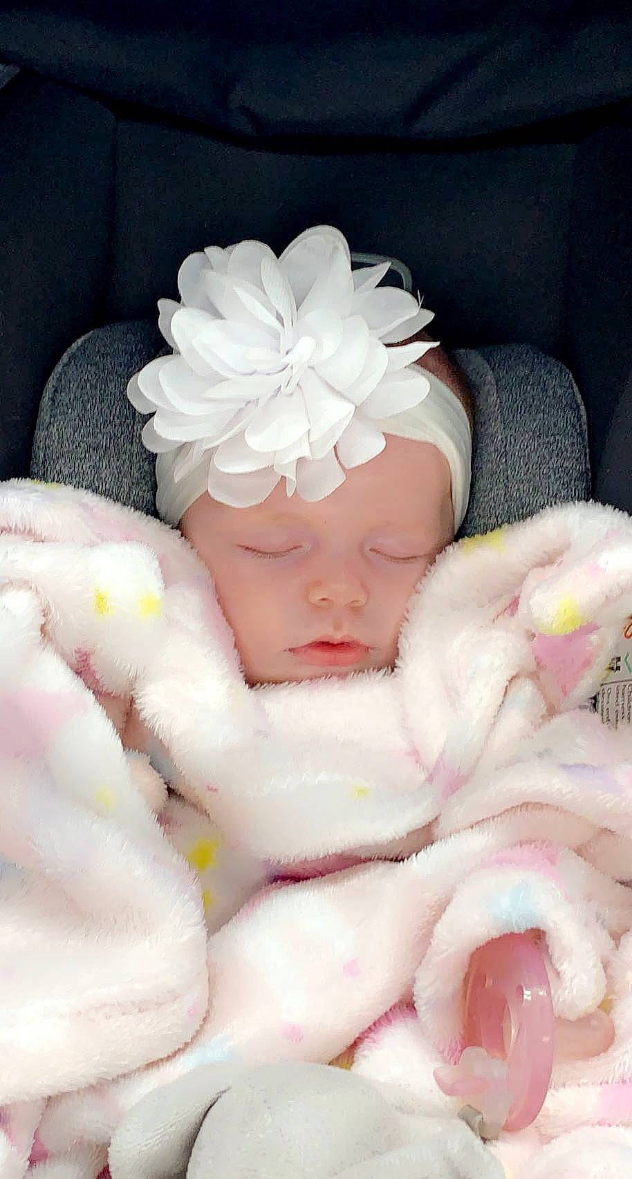 Emmalynn is registered to the contest to win money with this photo: baby, baby_products, baby_sleeping, baby_toddler_clothing, cap, comfort, fashion_accessory, flower, hand, hat, headgear, headwear, linens, nail, peach, person, petal, pink, sweetness, textile