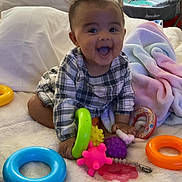Ariel joined the competition — help win amazing prizes! baby, bed, blanket, child, colorful, crib, cute, face, happy, indoor, infant, pajamas, pastel, person, plaid_clothing, playtime, room, smiling, soft, toys