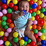 Ariel is registered to the contest to win money with this photo: baby, ball_pit, blue_ball, chewing, child, colorful, cute, diaper, fun, green_ball, happy, indoor, infant, orange_ball, pink_ball, playing, red_ball, smiling, toy, yellow_ball