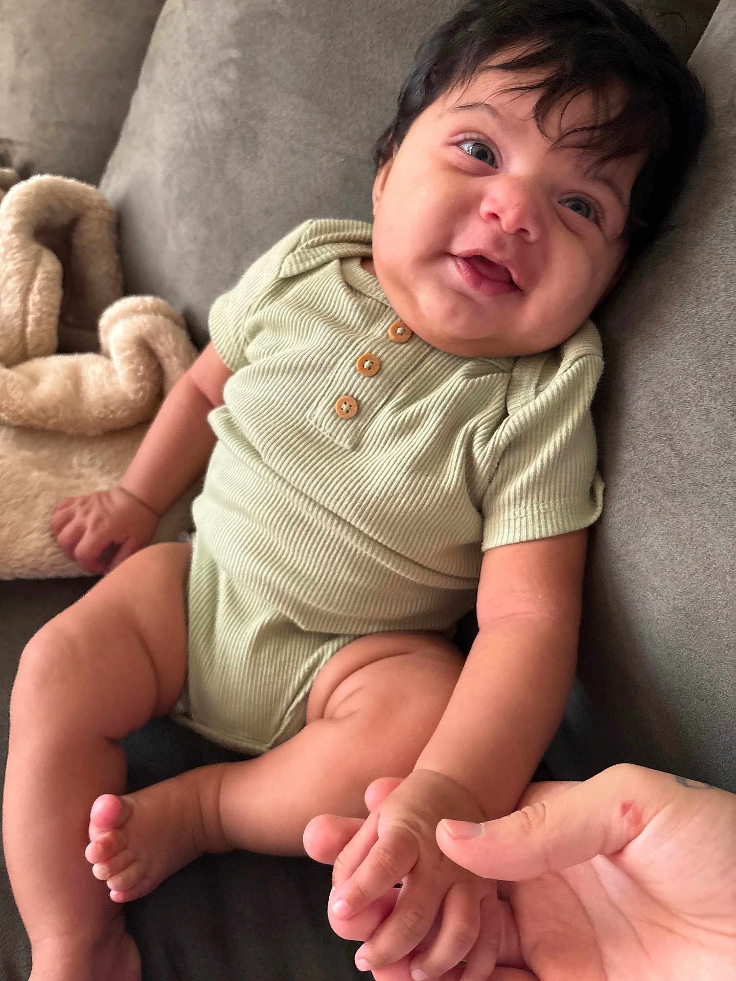 Saint joined the competition — help win amazing prizes! baby, infant, child, smiling, hand, couch, blanket, onesie, skin, face, fingers, foot, toe, soft, cute, indoor, person, portrait, seated, cozy