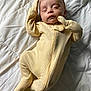 Camryn is registered to the contest to win money with this photo: baby, sleeping, yellow_onesie, infant, blanket, bed, quilted, cozy, peaceful, child, person, young, soft_lighting, indoors, cute, resting, relaxation, warm_clothing, portrait, lying_down