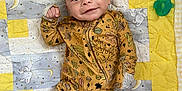 Camryn joined the competition — help win amazing prizes! baby, infant, smile, onesie, leaf_pattern, quilt, blanket, plush_toy, pacifier, indoor, cute, child, sleepwear, happy, lying_down, cozy, soft_toy, patterned_clothing, toddler, face