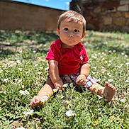 Axel is registered to the contest to win money with this photo: baby, barefoot, child, curious, daylight, face, flowers, garden, grass, greenery, nature, outdoor, plaid_shorts, portrait, red_shirt, sitting, sky, sunny, toddler, young_child