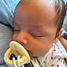 baby, sleeping, pacifier, blanket, onesie, infant, closeup, face, hand, soft_light, cozy, cute, resting, child, newborn, indoors, skin, hair, peaceful, comfort