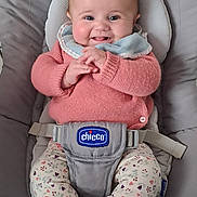 Camille a rejoint le concours — aidez-le/la à gagner de superbes lots ! baby, baby_bib, baby_seat, chicco, child, clothing, cute, face, floor_tiles, hands, happy, indoors, infant, patterned_pants, pink_sweater, portrait, seatbelt, smiling, socks, soft_toys