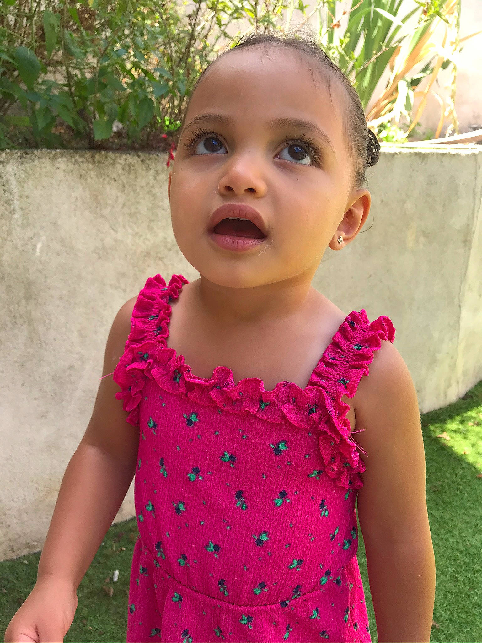 Maëlia participe au concours pour gagner de l'argent avec cette photo : baby_toddler_clothing, chin, dress, eye, face, facial_expression, green, hair, hairstyle, happy, head, iris, leaf, lip, neck, person, pink, plant, shoulder, skin