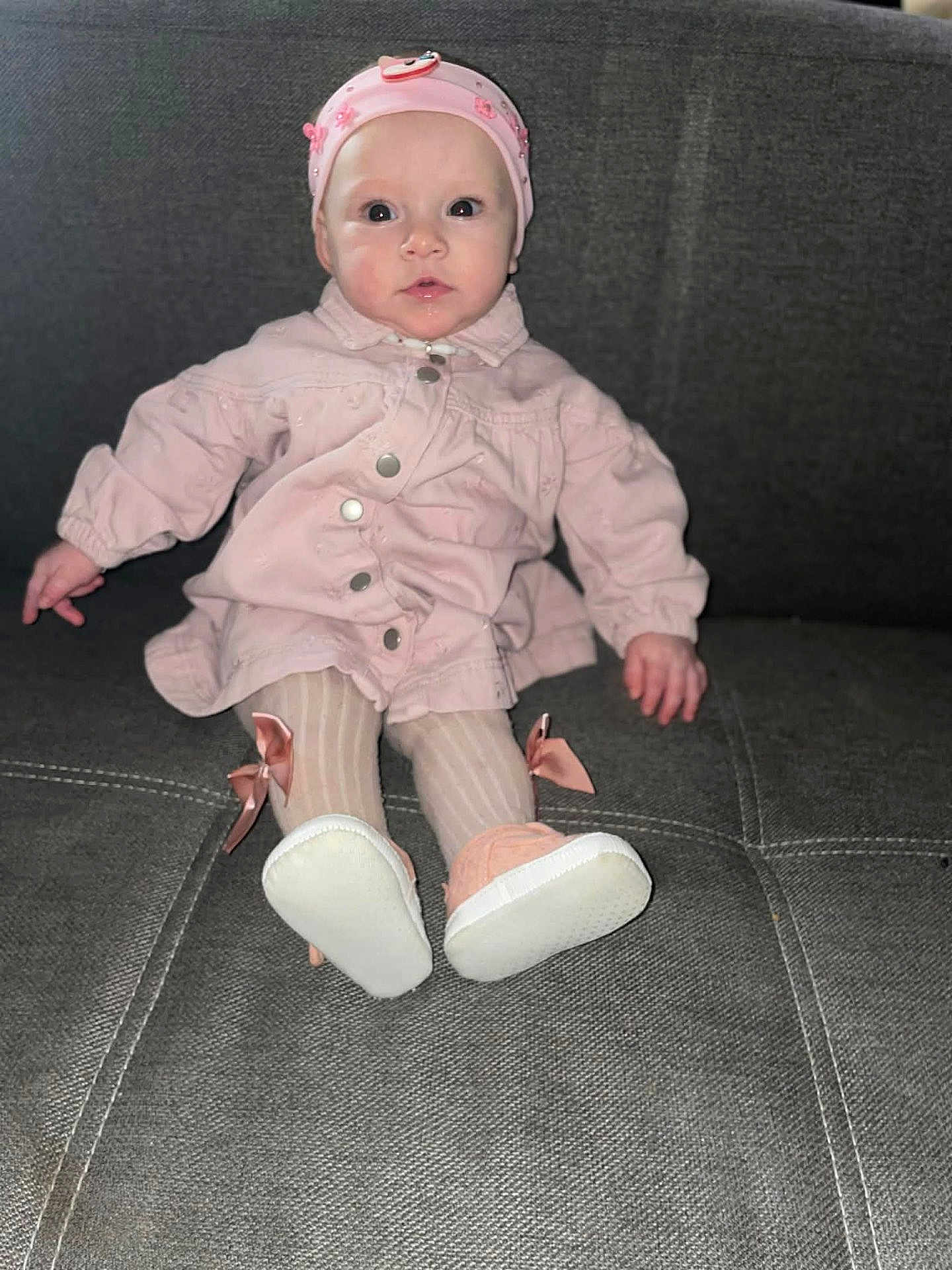 Rosslìa participe au concours pour gagner de l'argent avec cette photo : baby, infant, pink_hat, pink_jacket, striped_tights, bow, baby_shoes, sofa, couch, sitting, portrait, flash_photo, wide_eyes, face, hands, legs, cute, indoor, fabric, furniture