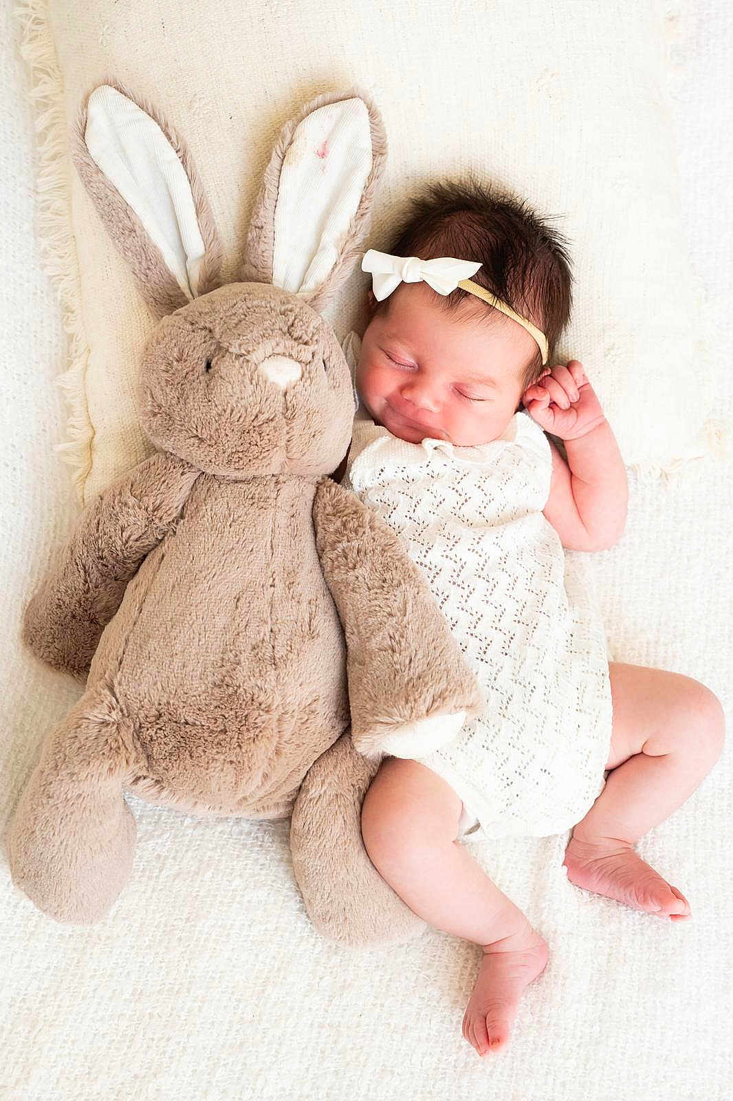 Everlie joined the competition — help win amazing prizes! baby, newborn, sleeping, plush_toy, bunny, soft, blanket, headband, white_dress, infant, cute, peaceful, child, soft_toy, lying_down, indoors, portrait, resting, cozy, adorable