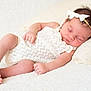 baby, sleeping, infant, white_clothing, headband, bow, pillow, blanket, soft_texture, peaceful, resting, cute, newborn, portrait, closeup, relaxation, indoor, child, skin, hair