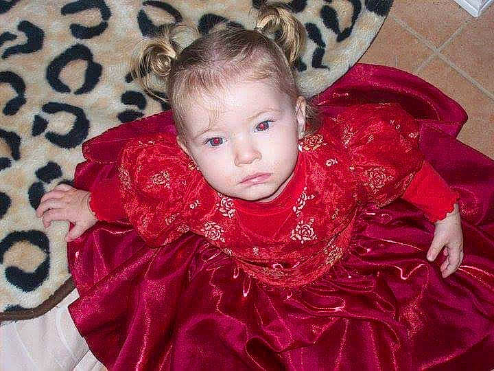 Kyra is registered to the contest to win money with this photo: baby_toddler_clothing, cheek, dress, embellishment, event, eyelash, face, fashion_design, fun, hair, head, headpiece, jewellery, magenta, pattern, person, petal, pink, sleeve, toddler