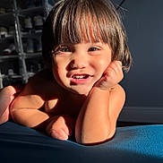 Megan is registered to the contest to win money with this photo: toddler, child, smile, face, hair, hand, arm, skin, light, shadow, indoor, furniture, shelf, shoe, background, portrait, expression, happy, resting, closeup