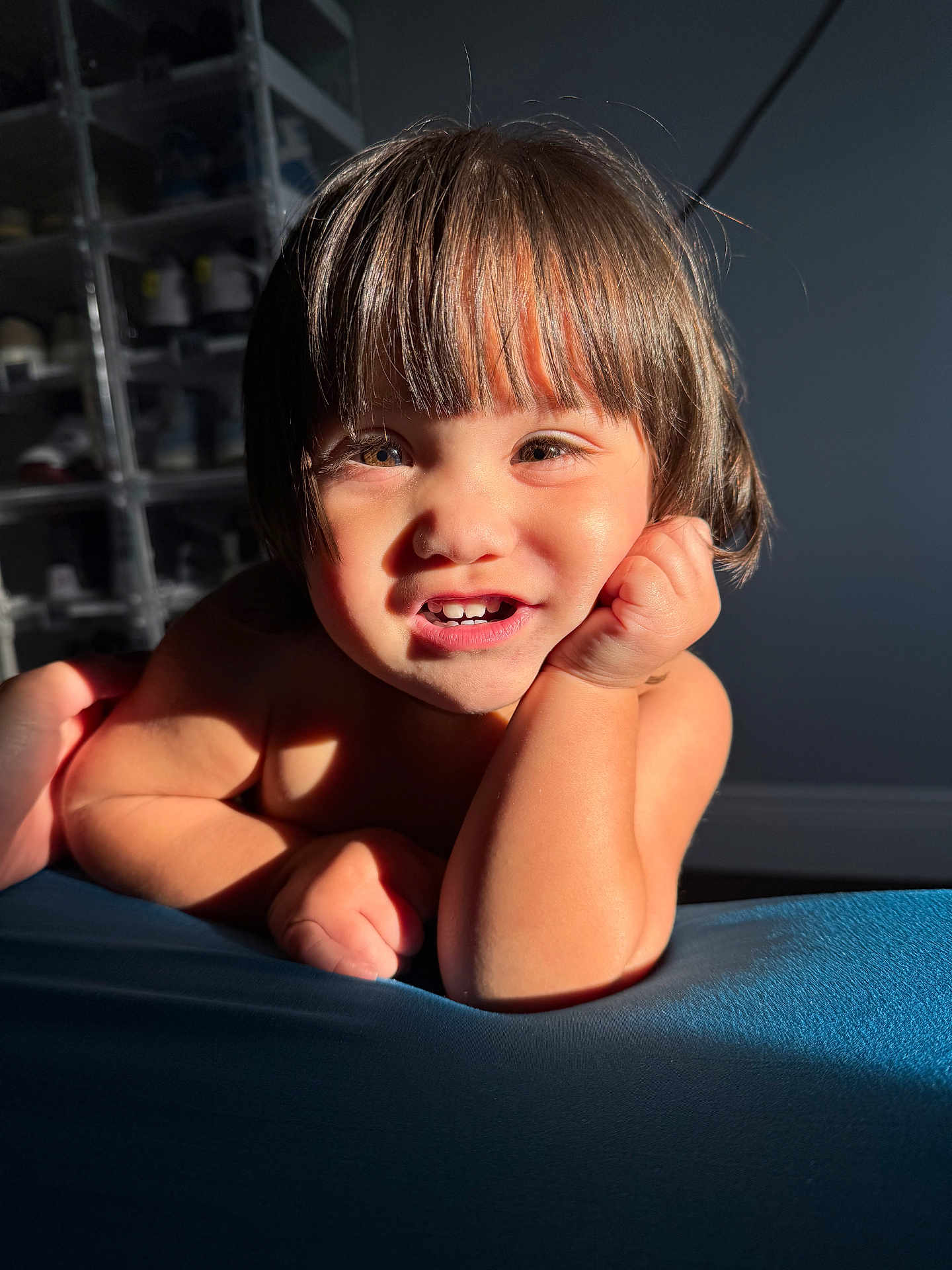 Megan is registered to the contest to win money with this photo: toddler, child, smile, face, hair, hand, arm, skin, light, shadow, indoor, furniture, shelf, shoe, background, portrait, expression, happy, resting, closeup