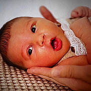 Romy participe au concours pour gagner de l'argent avec cette photo : baby, infant, face, hand, blanket, curious, close_up, skin, expression, newborn, portrait, lying_down, texture, soft, young_child, cute, human, mouth_open, eyes, resting