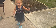 Paige joined the competition — help win amazing prizes! child, girl, pigtails, dress, blue_shoes, sidewalk, garden_bed, grass, house, brick_wall, potted_plants, outdoor, daylight, smile, person, concrete, white_bows, lawn, golf_cart, casual
