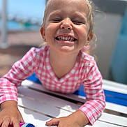 Paige joined the competition — help win amazing prizes! child, smiling, outdoor, sunlight, table, pink_clothing, checkered_pattern, happy, face, hands, blond_hair, daylight, playful, casual, person, portrait, summer, closeup, joy, fun