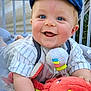 baby, blue_eyes, cap, cheeky_grin, clothing, colorful_toy, crib, cute, expression, face, happy, infant, indoors, looking_at_camera, plush_toy, smile, soft_toys, sitting, toy, young_child